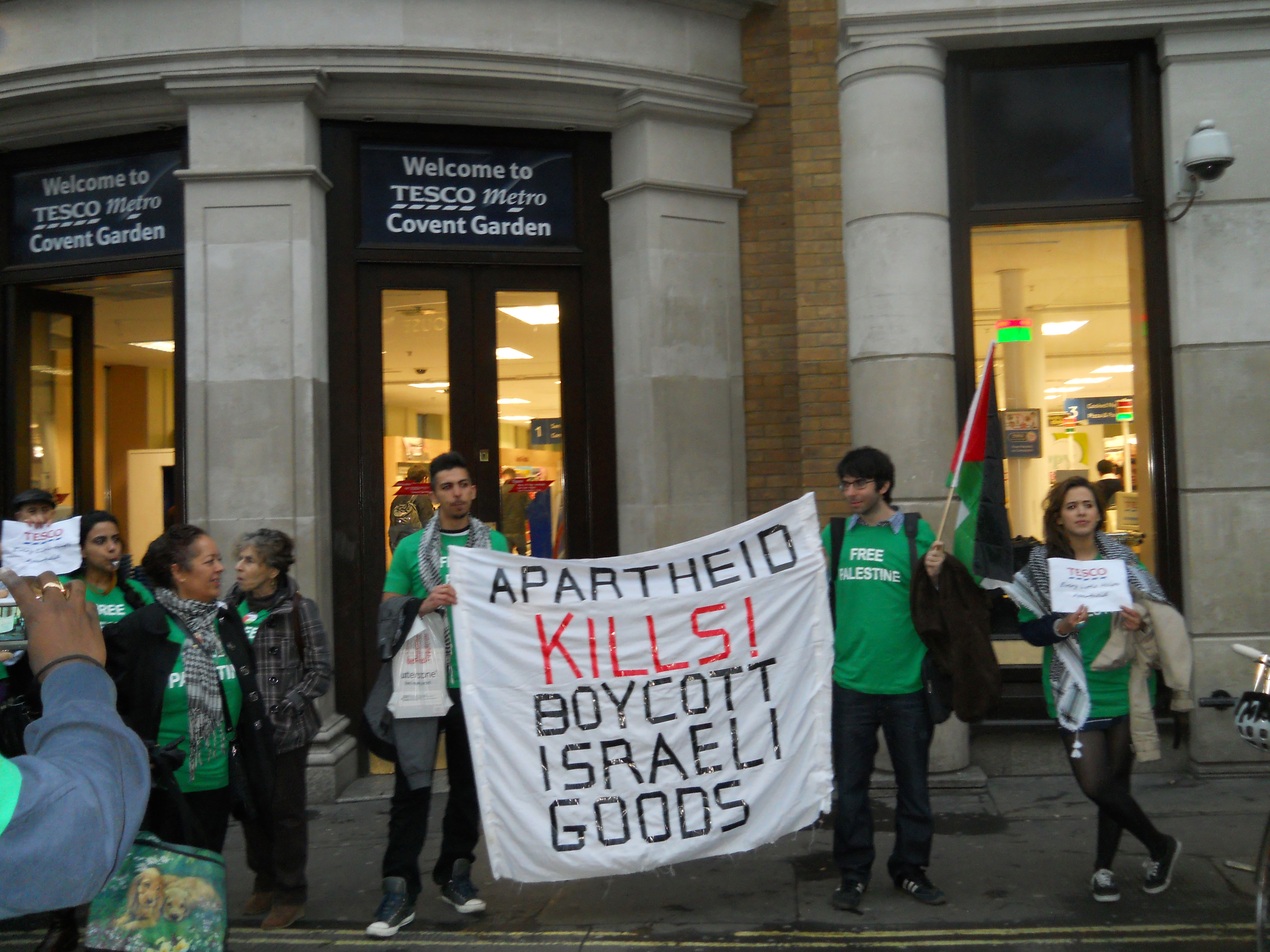 BDS mobs converge on Tesco supermarket in UK during a day of BDS protest in 2011. BDS activists raided stores and deshelved Israeli goods while demonstrators drew attention outside. 